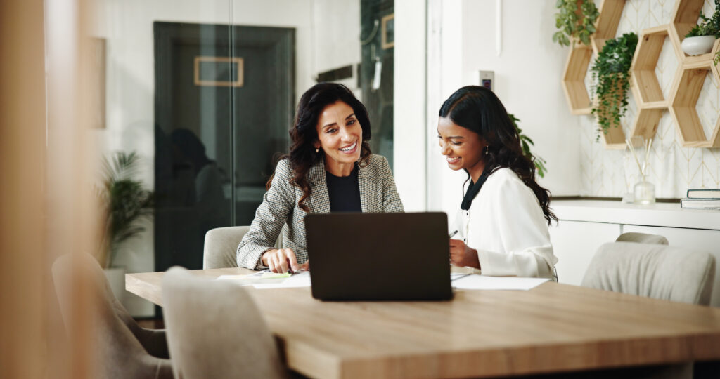 Attorney and legal assistant reviewing a case together on a laptop in a modern office